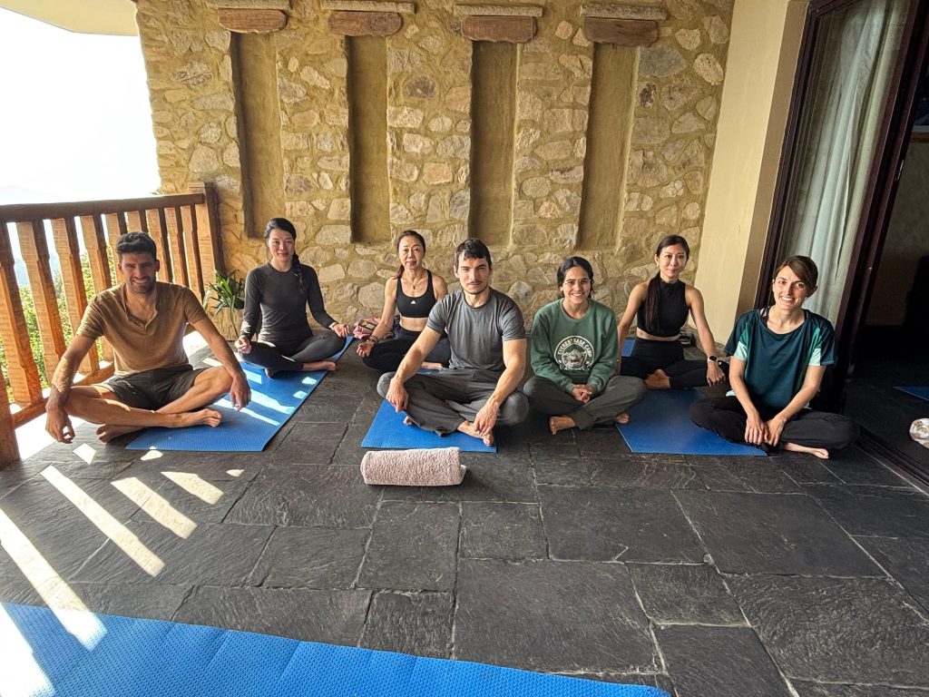 Meditation retreat participants sitting together with smiles after a silent meditation session in the hills of Pokhara, Nepal