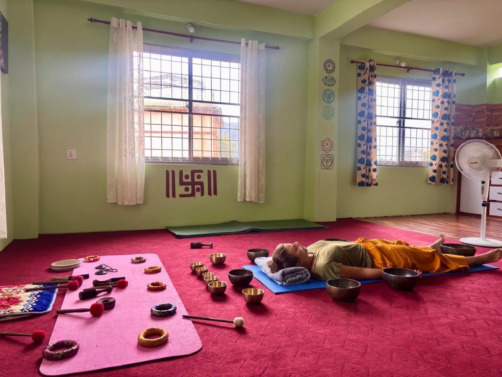 Woman relaxing during a Himalayan singing bowl sound healing session in Pokhara, Nepal